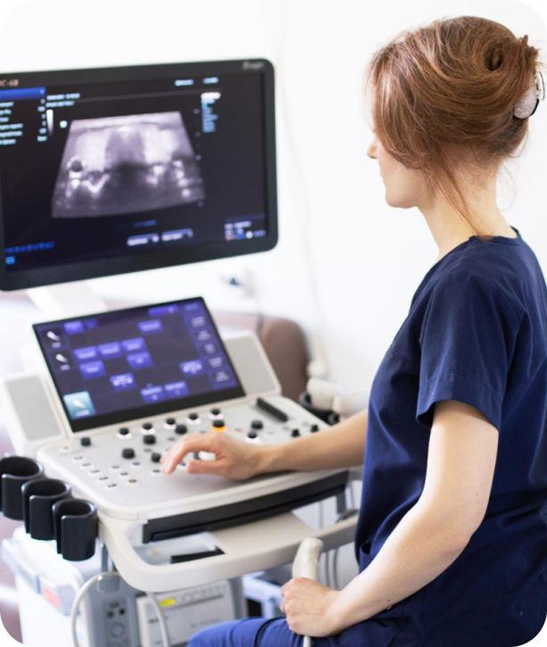 Ultrasound technician operating diagnostic system in ER setting, delivering mobile imaging with HIPAA-compliant workflows.